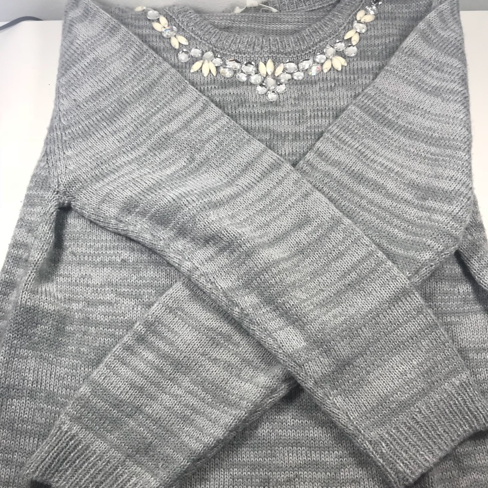 This gray sweater is paired with a jeweled collar.